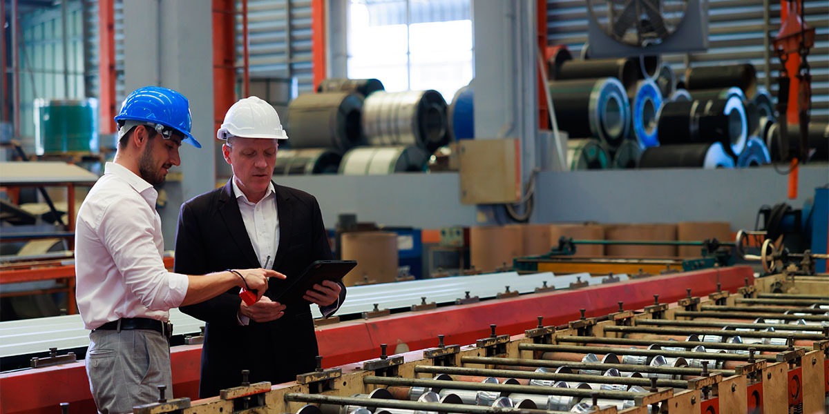 Caucasian business man and Factory engineer talking about hidden factory potential at Heavy Industry Manufacturing Factory. worker in safety hardhat at factory industrial facilities